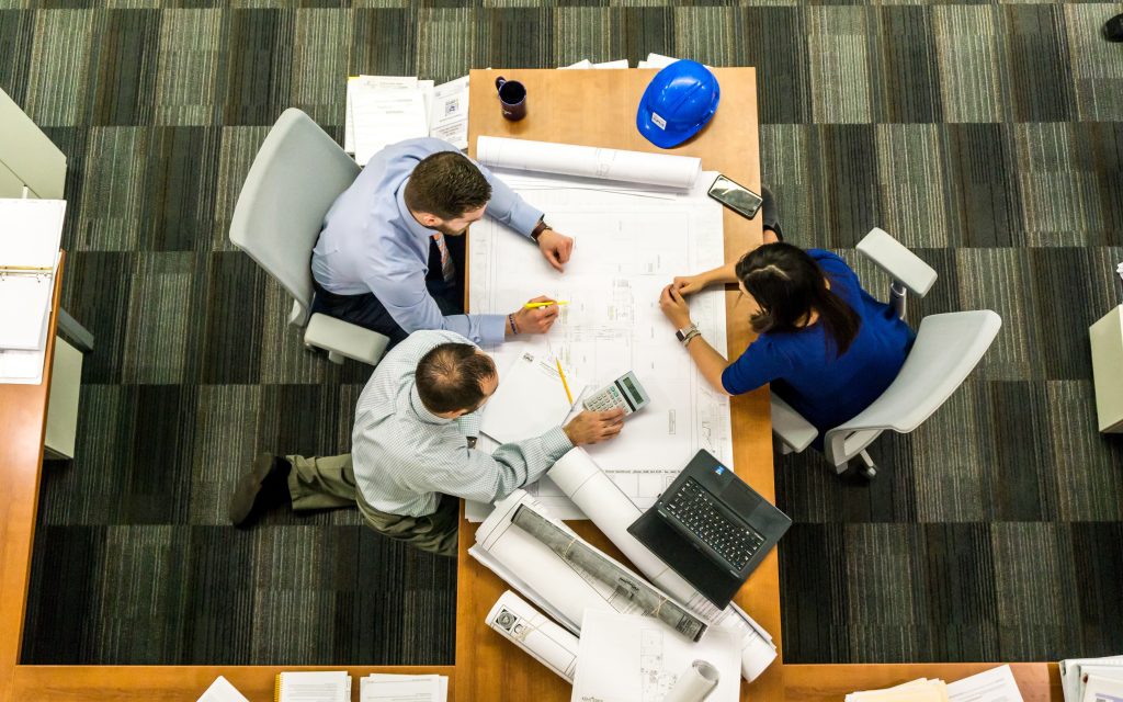 Equipo profesional revisando planos y documentación para pases ejecutivos